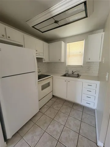 a kitchen with granite countertop a sink window and white stainless steel appliances