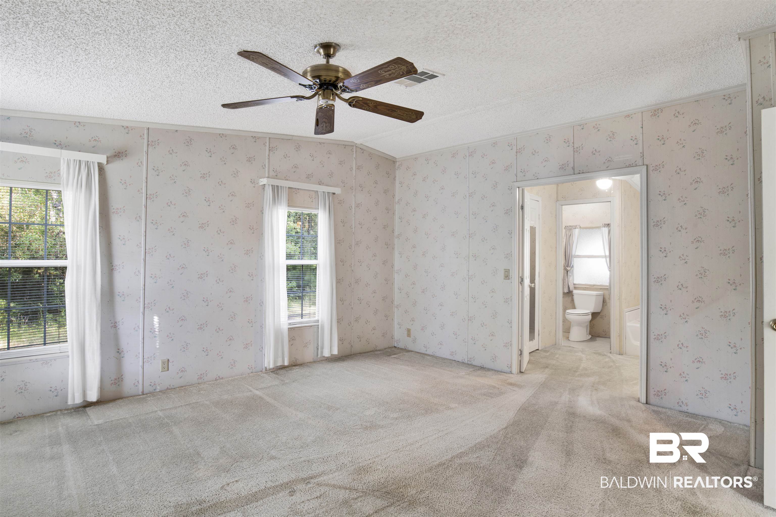 1216 Ridgewood Drive Lillian, AL 36549 - Photo 11 of 29 Empty room with carpet, a textured ceiling, wallpapered walls, ornamental molding, and a ceiling fan