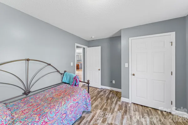 a bedroom with a large bed and a chandelier