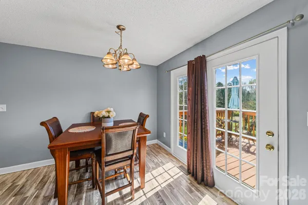 a dining room with furniture a chandelier and wooden floor