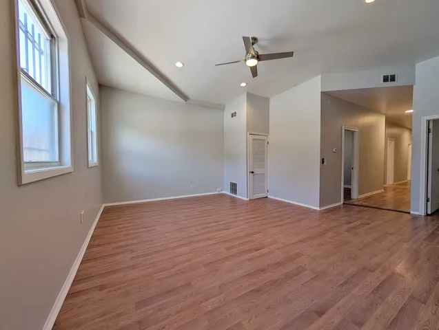 a view of empty room with wooden floor