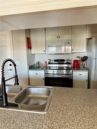 a kitchen with stainless steel appliances granite countertop a refrigerator stove and microwave