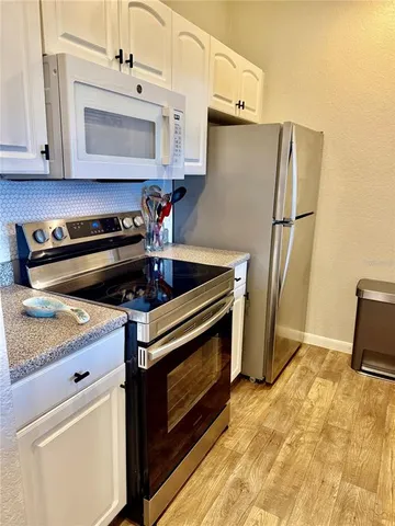 a kitchen with stainless steel appliances granite countertop a sink dishwasher stove and refrigerator