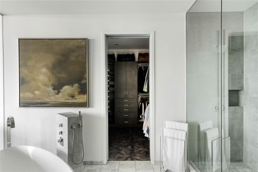 45 Ivan Allen Jr Boulevard Northwest, Unit 1702 Atlanta, GA 30308 - Photo 44 of 94 a bathroom with a painting on the wall and a shower