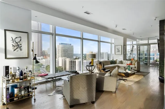 a living room with furniture and a large window with wooden floor