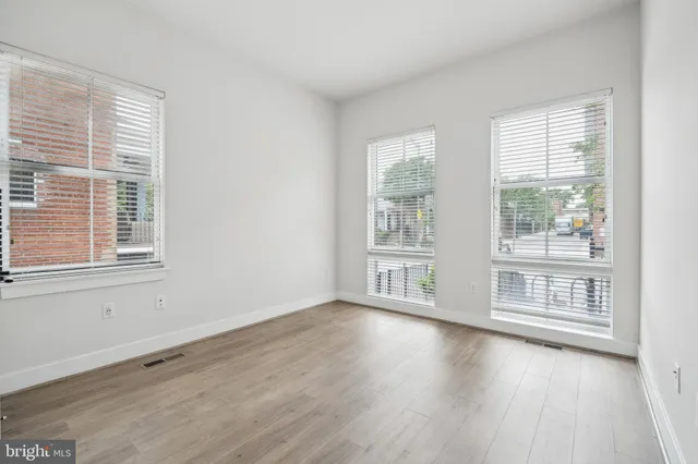 an empty room with wooden floor and closet