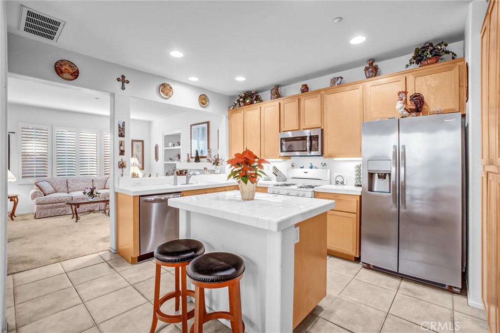 65 Windward Way Buena Park, CA 90621 - Photo 15 of 50 a kitchen with stainless steel appliances kitchen island granite countertop a sink refrigerator and cabinets