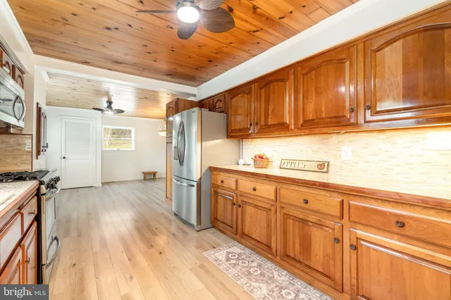 a kitchen with stainless steel appliances granite countertop a refrigerator and a stove top oven