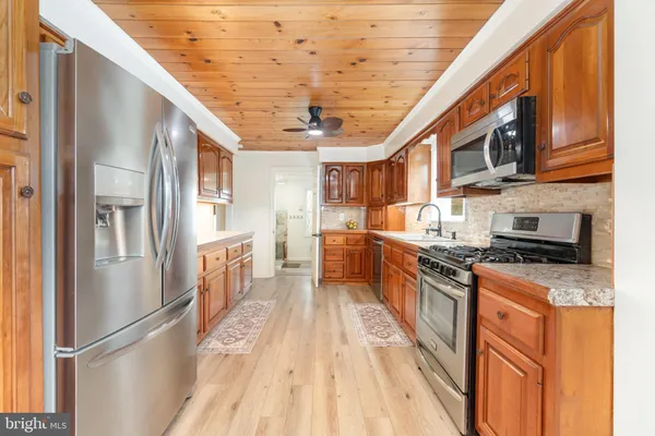 a view of empty room with wooden floor and fireplace
