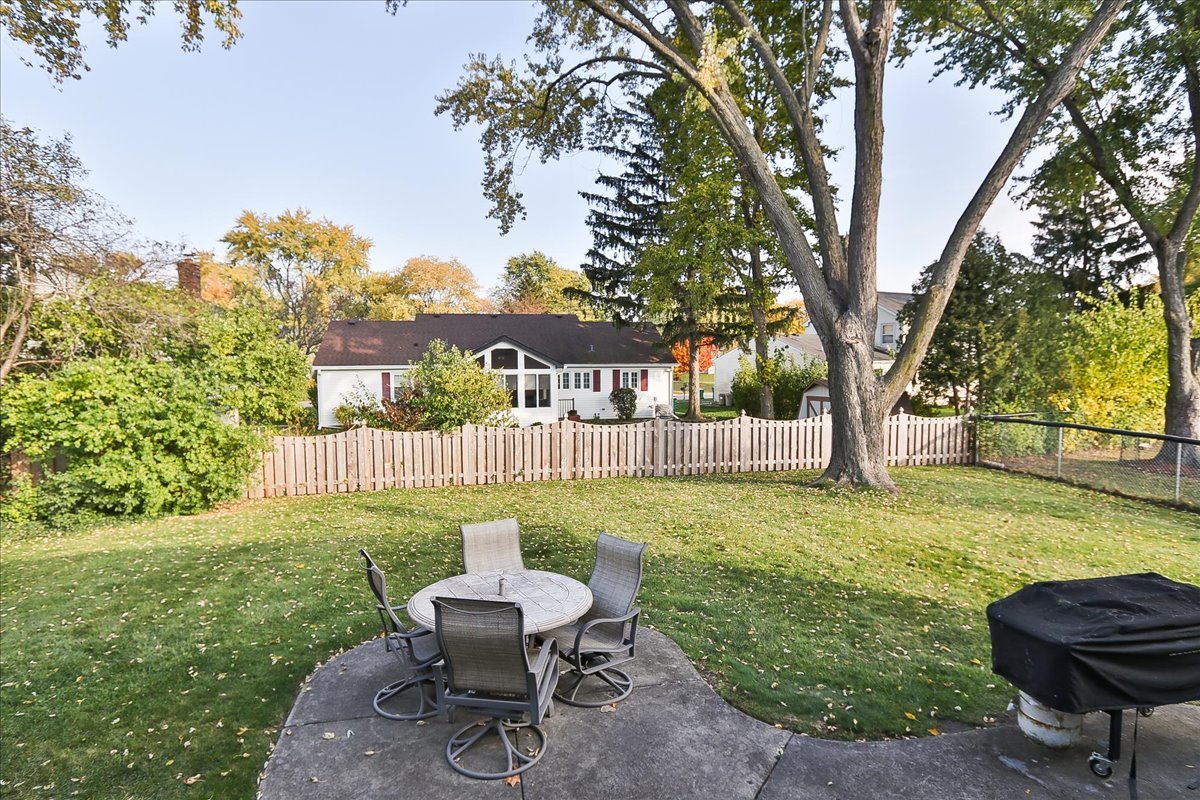 760 Checker Drive Buffalo Grove, IL 60089 - Photo 28 of 29 a view of a backyard with table and chairs potted plants and a large tree