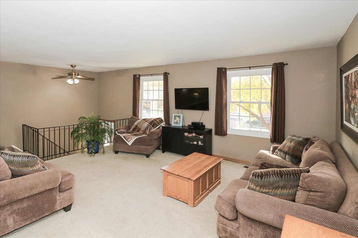 760 Checker Drive Buffalo Grove, IL 60089 - Photo 5 of 29 a living room with furniture and a flat screen tv