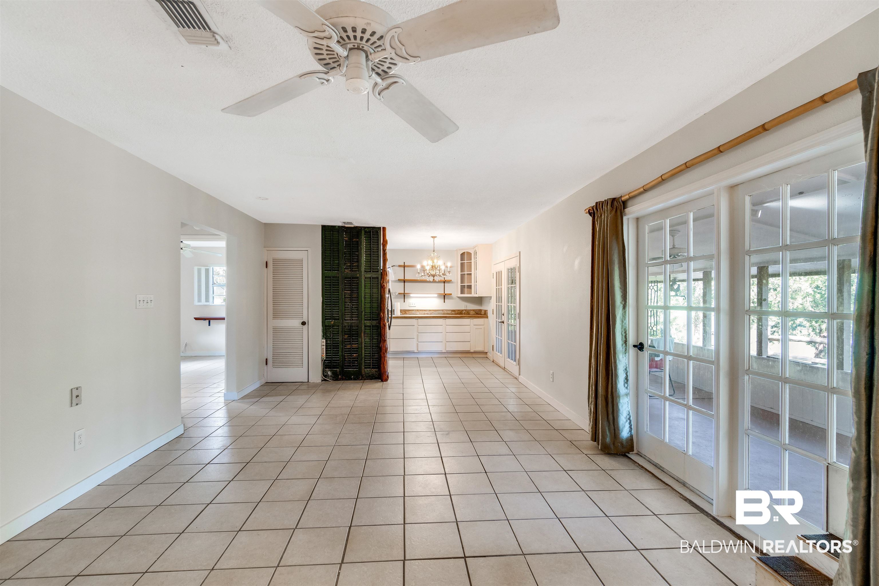 34341 Lost River Road Seminole, AL 36574 - Photo 6 of 36 Empty room with ceiling fan, a chandelier, and light tile patterned flooring
