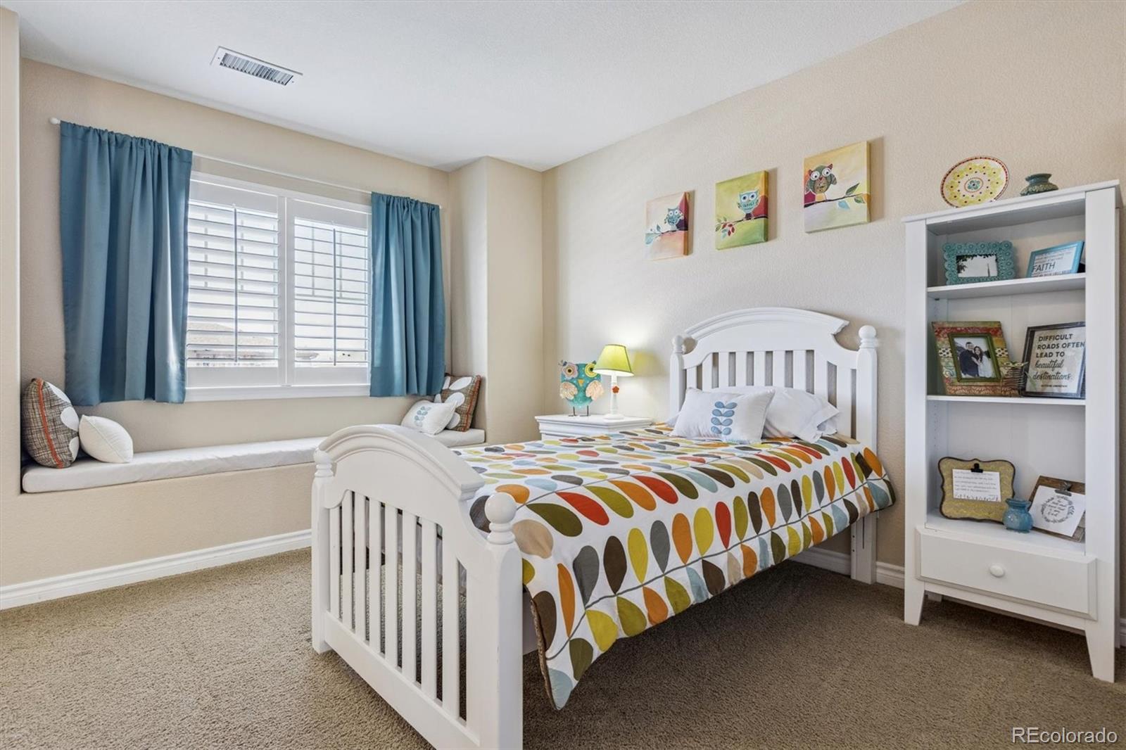 10822 Glengate Circle Highlands Ranch, CO 80130 - Photo 22 of 47 a bedroom with a bed a dresser and a large window