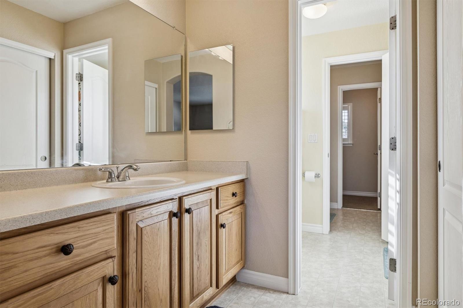 10822 Glengate Circle Highlands Ranch, CO 80130 - Photo 25 of 47 a bathroom with a granite countertop sink and a mirror