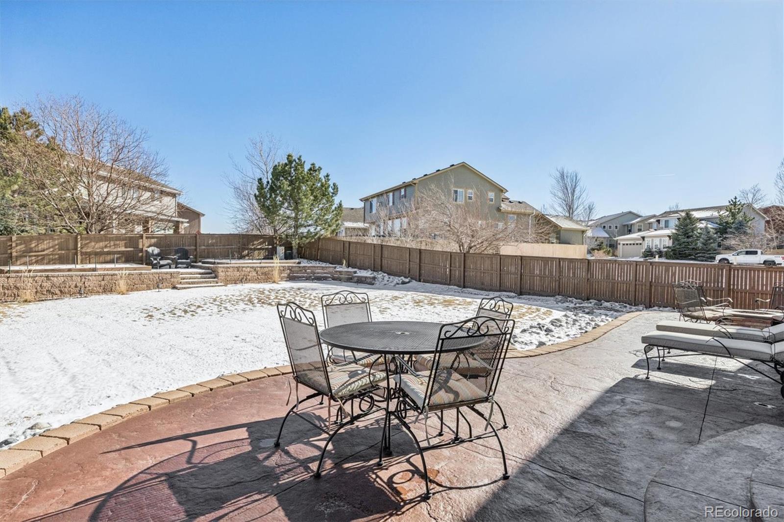 10822 Glengate Circle Highlands Ranch, CO 80130 - Photo 38 of 47 a view of a patio with table and chairs with wooden floor and fence