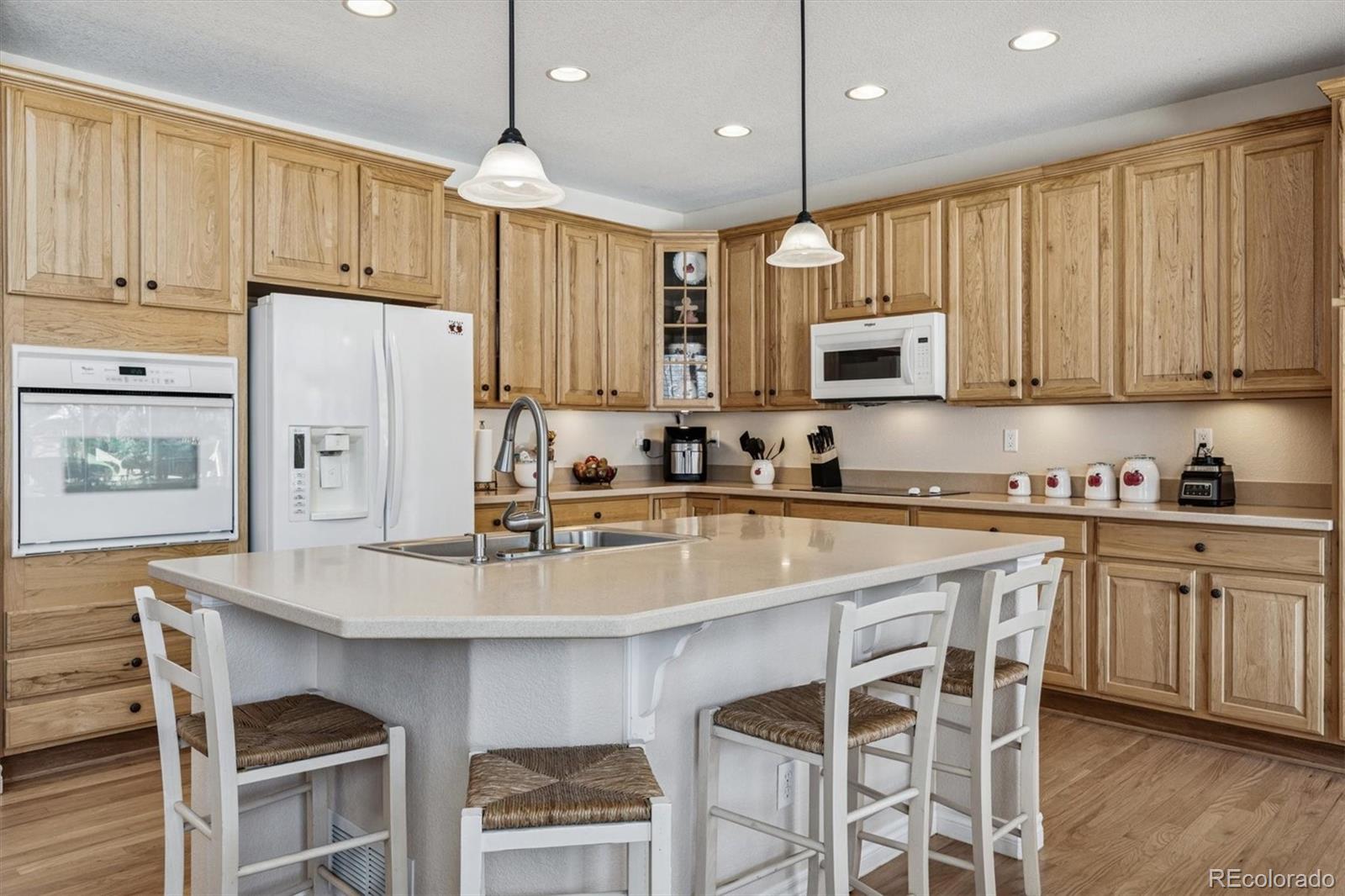 10822 Glengate Circle Highlands Ranch, CO 80130 - Photo 8 of 47 a kitchen with stainless steel appliances granite countertop a refrigerator a sink dishwasher a stove and white cabinets with wooden floor