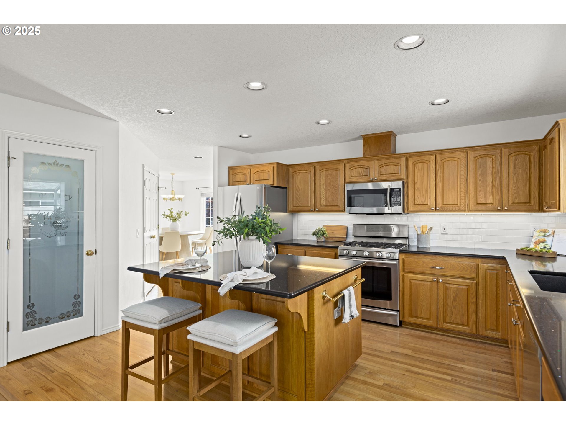 22271 Northeast Lachenview Lane Fairview, OR 97024 - Photo 12 of 40 a kitchen with stainless steel appliances kitchen island granite countertop a sink and cabinets