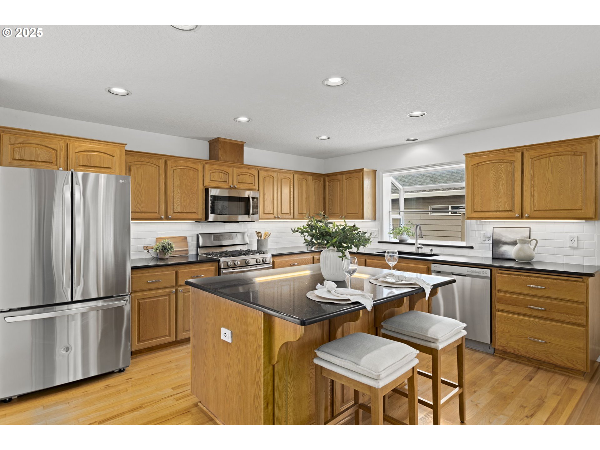 22271 Northeast Lachenview Lane Fairview, OR 97024 - Photo 10 of 40 a kitchen with stainless steel appliances granite countertop a sink a stove a refrigerator cabinets and chairs