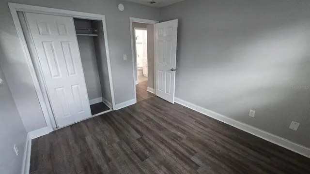 an empty room with wooden floor and closet