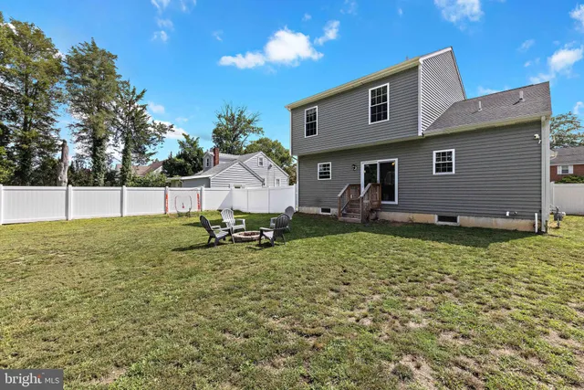 a view of a swimming pool with a bench and trees around