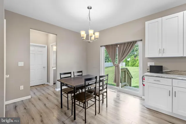 a view of a dining room with furniture a chandelier and wooden floor