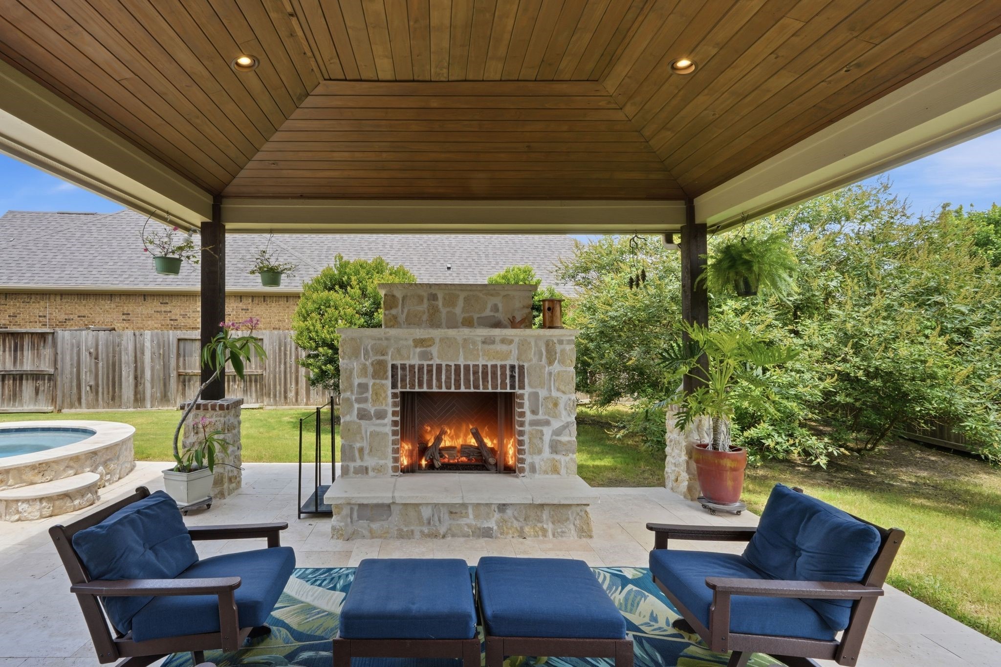 27705 South Slate Hills Lane Spring, TX 77386 - Photo 33 of 45 Extended covered patio featuring a stunning custom gas log fireplace for year-round ambiance.