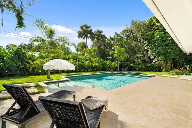 a patio with a table and chairs under an umbrella
