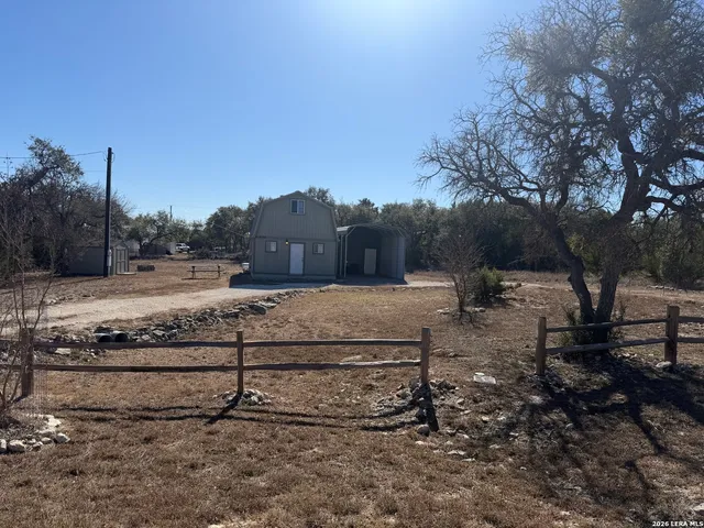 a view of a yard with wooden fence
