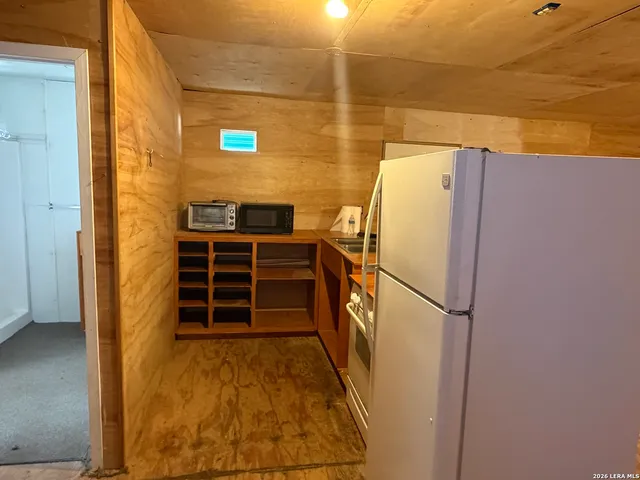 a white refrigerator freezer and a stove sitting inside of a kitchen