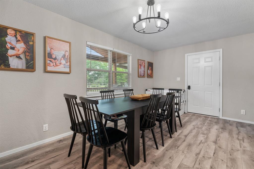 360 County Road 4358 Decatur, TX 76234 - Photo 6 of 38 Dining room with light wood-type flooring, a textured ceiling, baseboards, and a notable chandelier