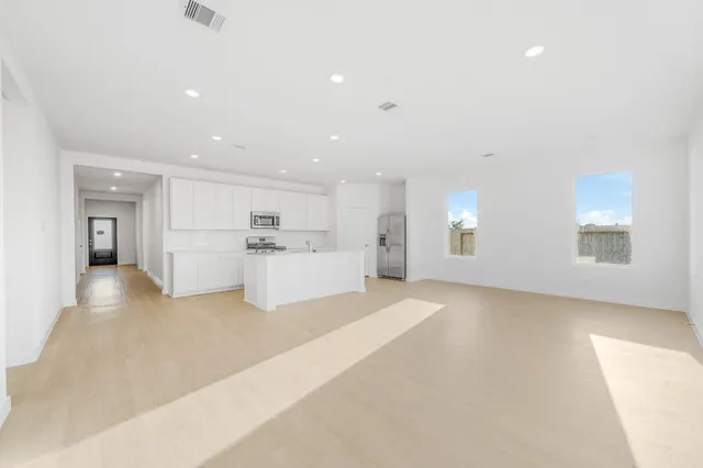 a view of a kitchen with a sink and dishwasher a refrigerator with white cabinets