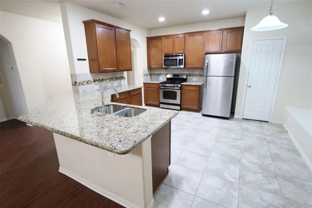 a kitchen with stainless steel appliances granite countertop a refrigerator stove microwave and sink