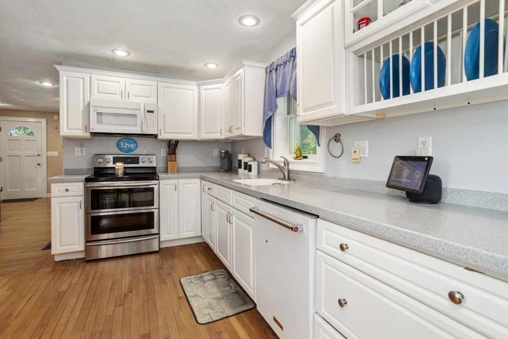 2 Allen Road Billerica, MA 01821 - Photo 12 of 32 a kitchen with granite countertop a stove a cabinets and wooden floor