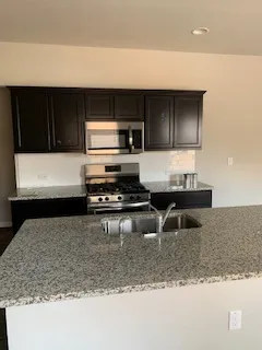 a kitchen with kitchen island stainless steel appliances a sink and a counter top