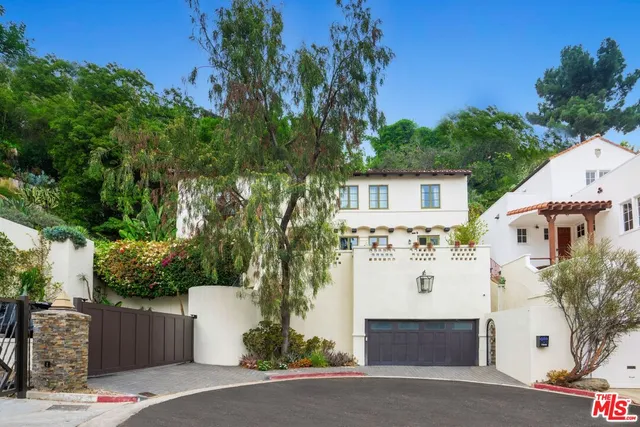a view of white house with a yard and potted plants