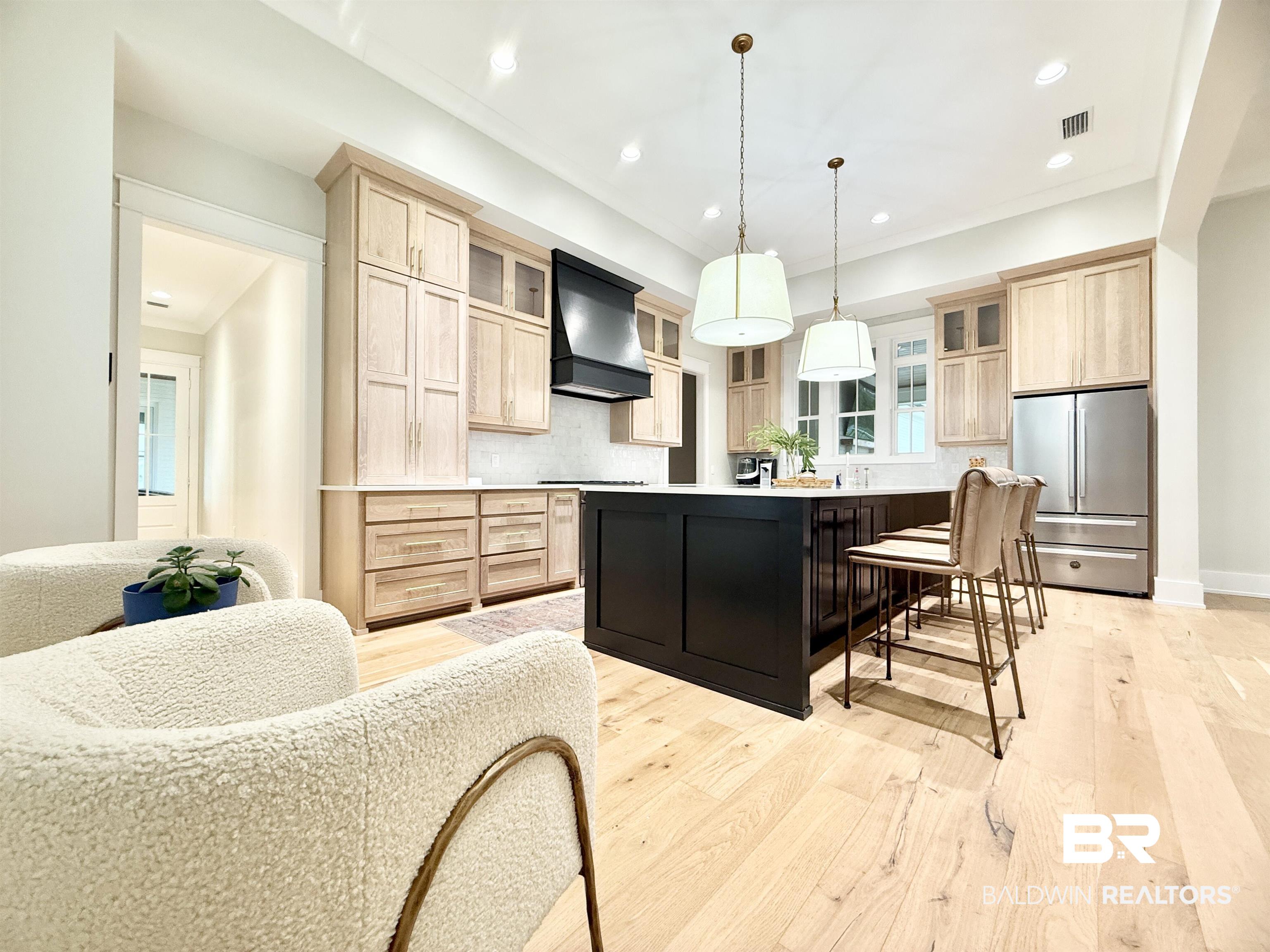 21767 Gallery Boulevard Fairhope, AL 36532 - Photo 10 of 74 Kitchen featuring light brown cabinetry, freestanding refrigerator, light wood-style floors, custom exhaust hood, and recessed lighting