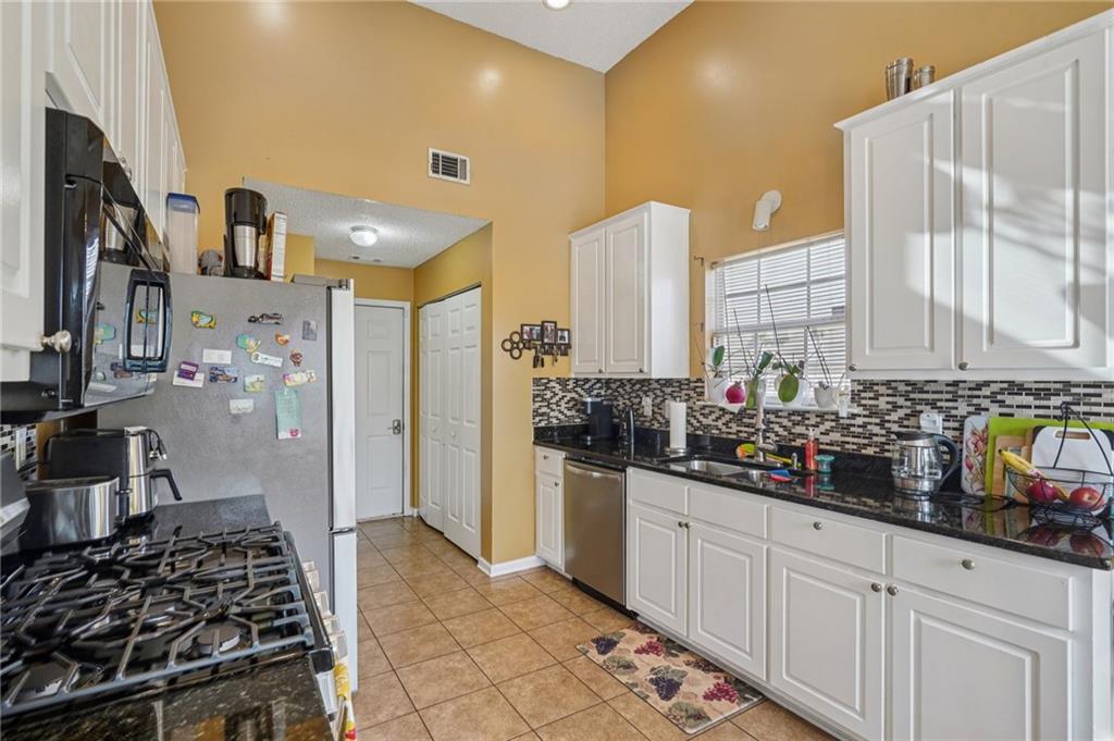4496 Jackam Ridge Court Lithonia, GA 30038 - Photo 11 of 24 a kitchen with stainless steel appliances a stove and a refrigerator