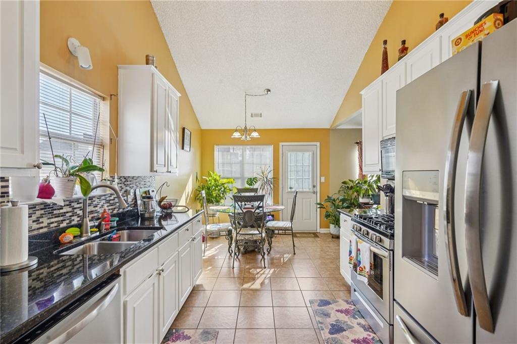 4496 Jackam Ridge Court Lithonia, GA 30038 - Photo 13 of 24 a kitchen with stainless steel appliances a sink a counter top space and a window