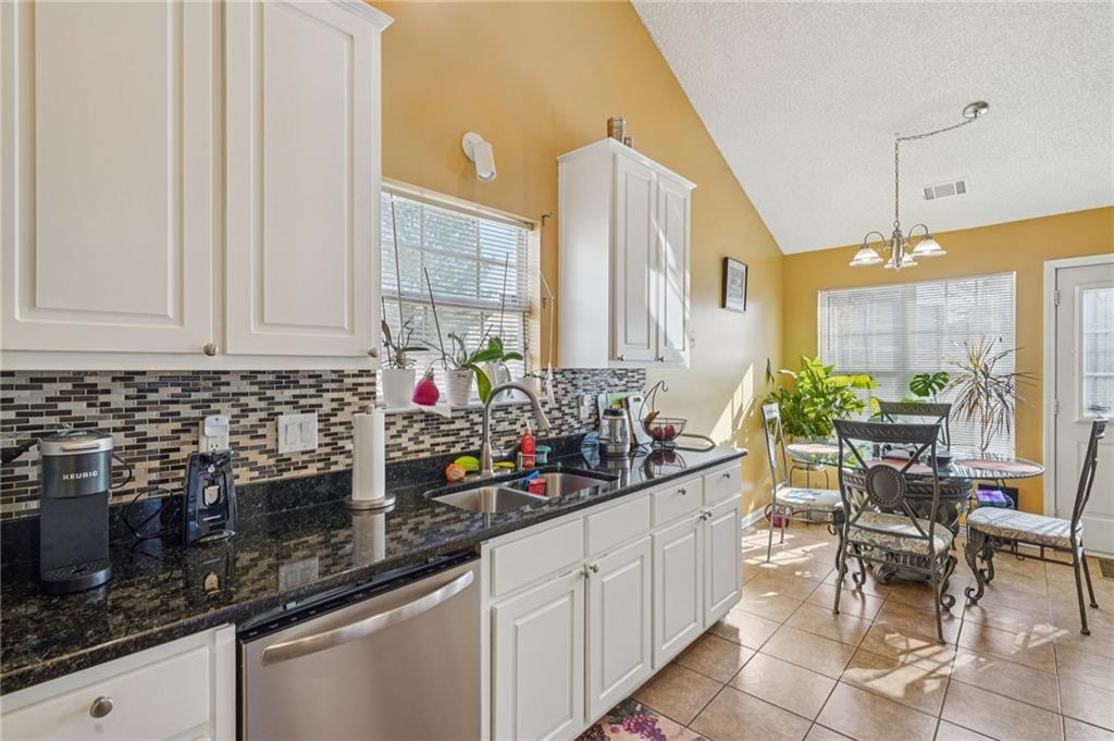 4496 Jackam Ridge Court Lithonia, GA 30038 - Photo 14 of 24 a kitchen with stainless steel appliances granite countertop a sink and cabinets