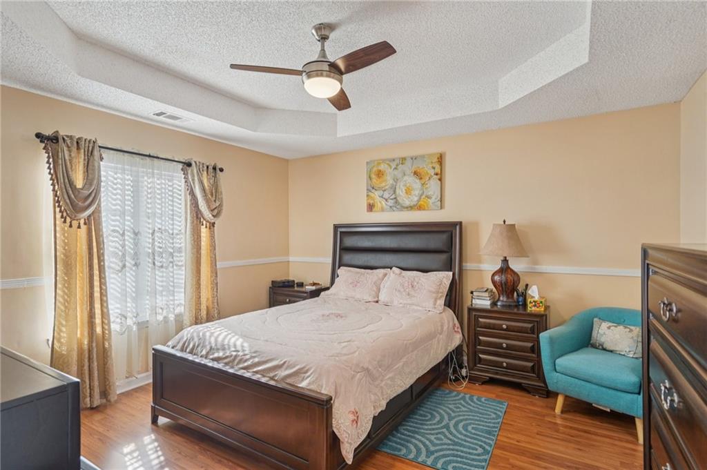 4496 Jackam Ridge Court Lithonia, GA 30038 - Photo 20 of 24 a bedroom with a bed a couch and a chandelier