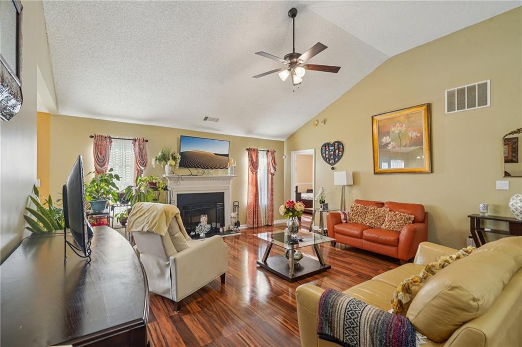 4496 Jackam Ridge Court Lithonia, GA 30038 - Photo 4 of 24 a living room with furniture a fireplace and a flat screen tv