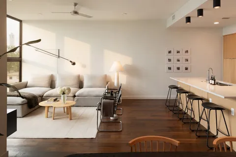 a living room with couches chairs and closet with wooden floor