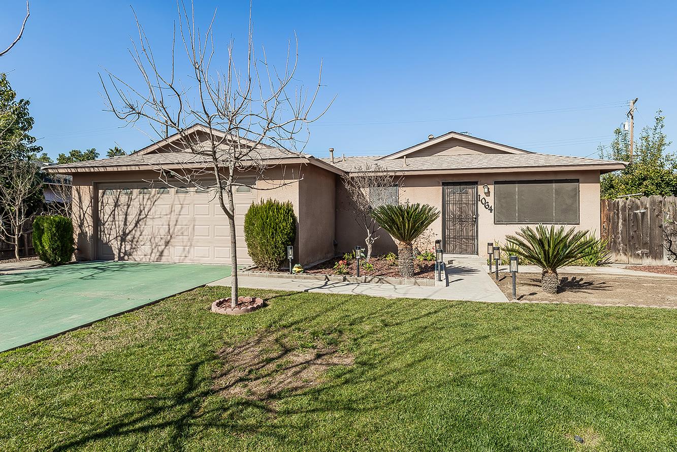 a view of house with yard and outdoor seating