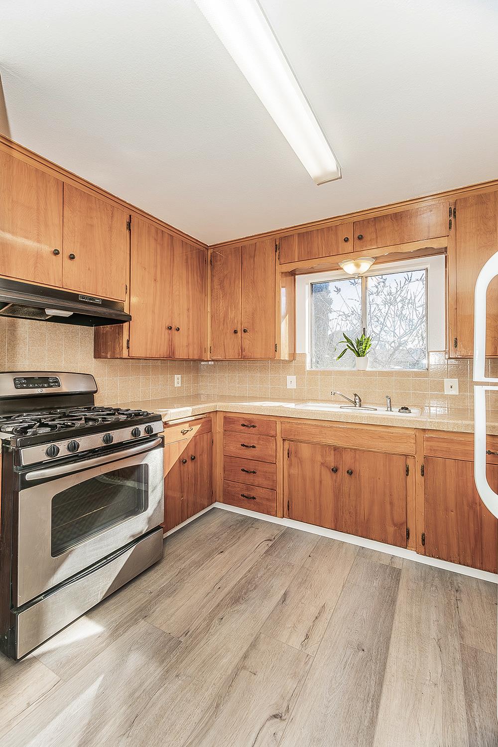 1064 East Early Avenue Reedley, CA 93654 - Photo 11 of 36 a kitchen with stainless steel appliances granite countertop a stove a sink and a refrigerator