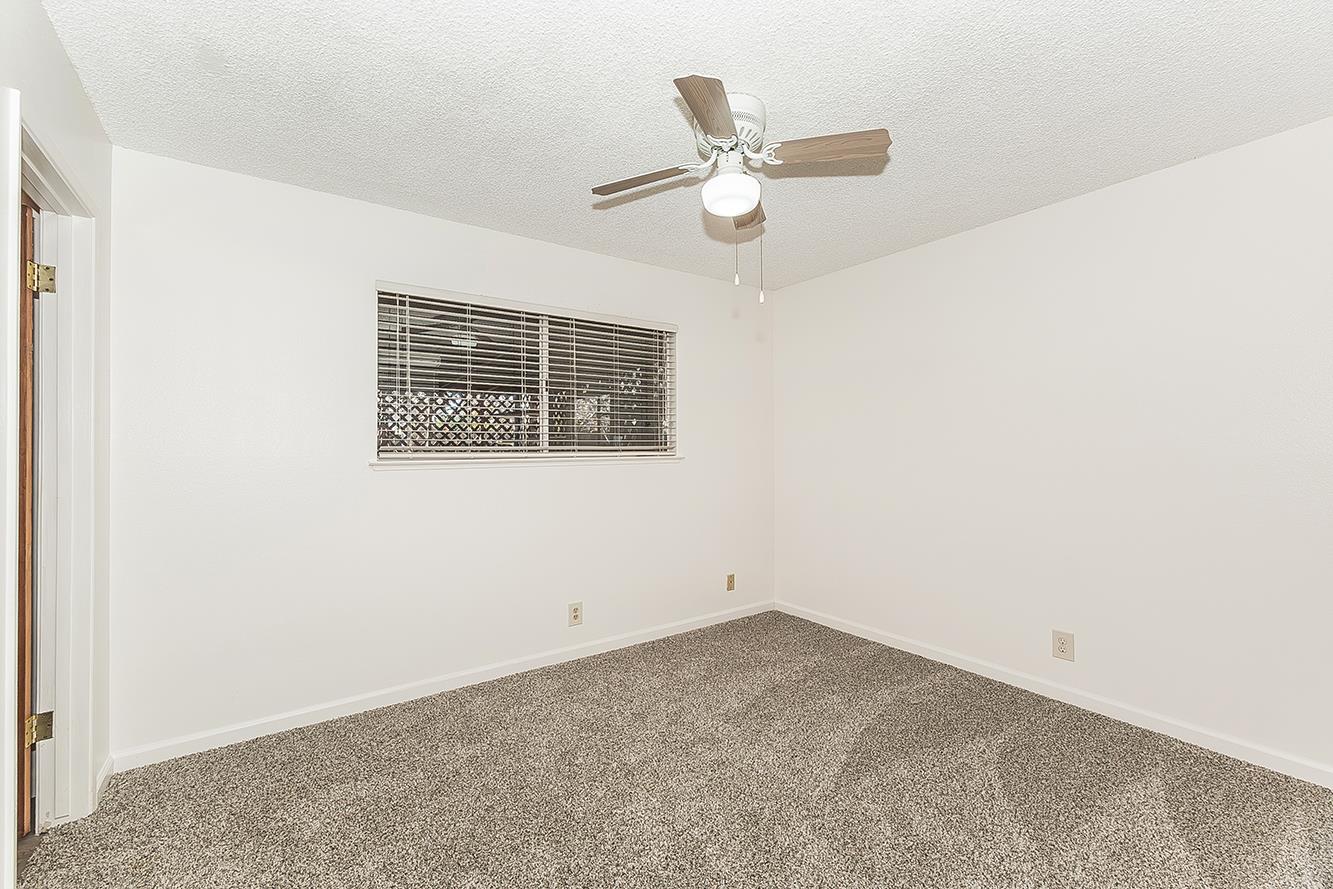 1064 East Early Avenue Reedley, CA 93654 - Photo 12 of 36 an empty room with a window and ceiling fan