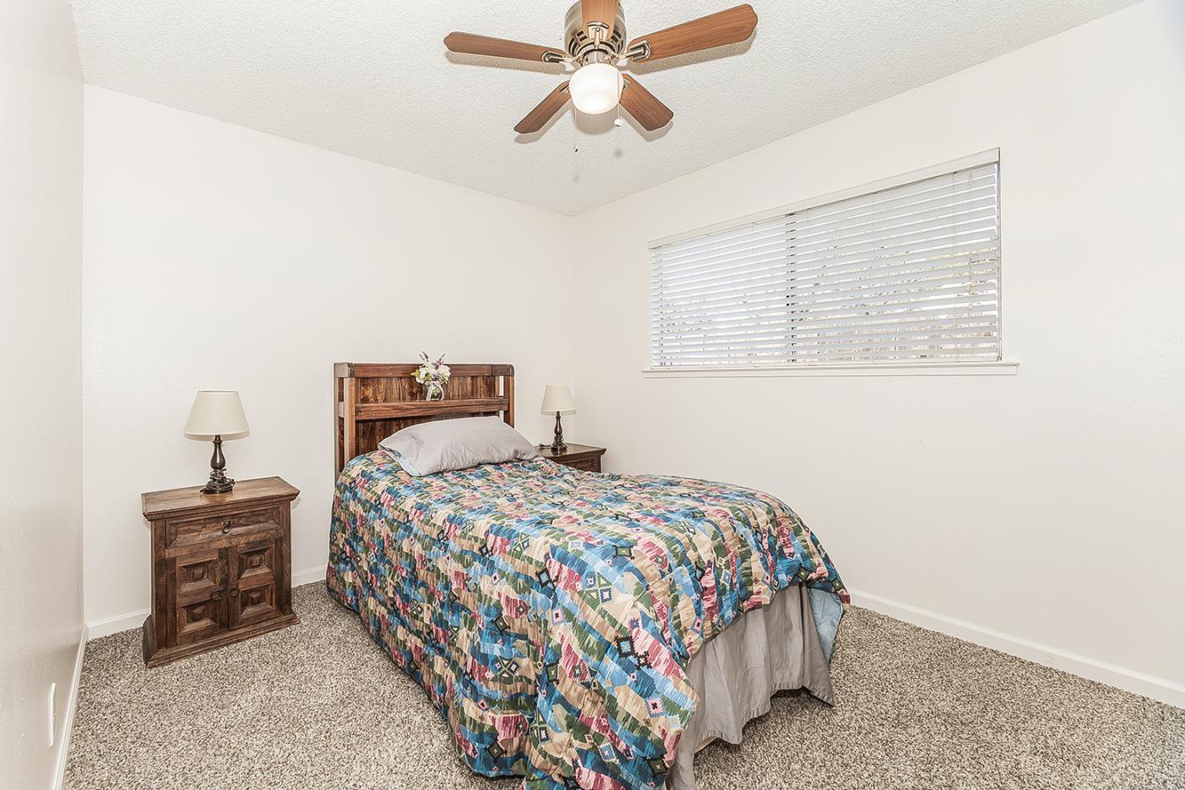 1064 East Early Avenue Reedley, CA 93654 - Photo 18 of 36 a bedroom with a bed and a chandelier