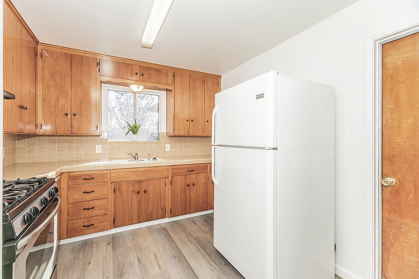 1064 East Early Avenue Reedley, CA 93654 - Photo 9 of 36 a kitchen with a refrigerator and a sink