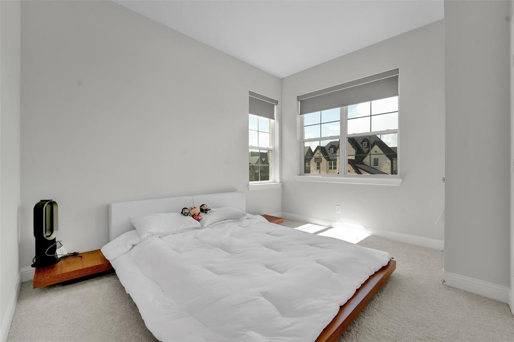 3520 Helios Lane Corinth, TX 76208 - Photo 27 of 37 Bedroom with light gray wall paint, two large windows, white window trim, and light-colored carpet flooring