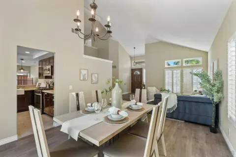a view of a dining room with furniture a chandelier and wooden floor