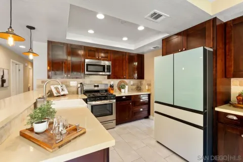 a kitchen with kitchen island granite countertop stainless steel appliances a refrigerator a stove top oven and cabinets